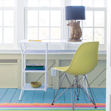 Bright home office with colorful floor and white furniture, featuring creative coastal-inspired paint choices.