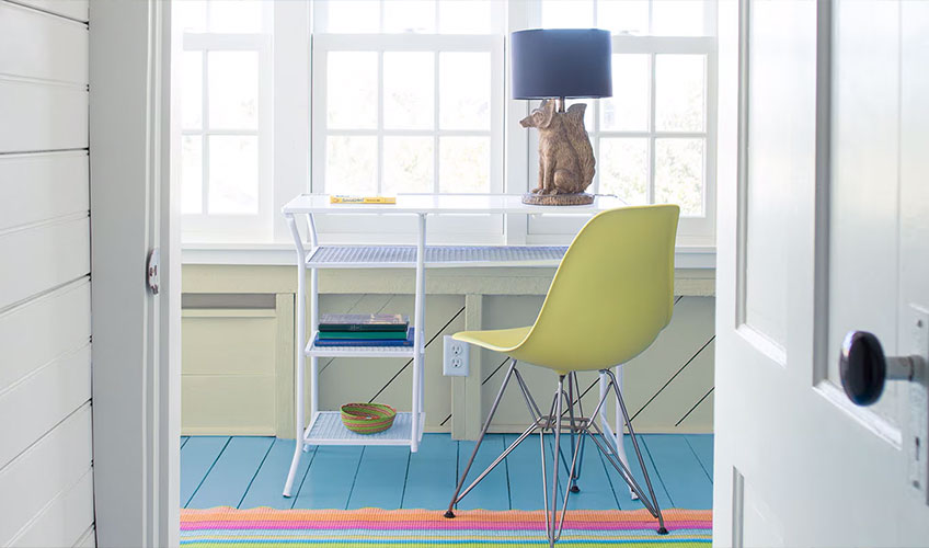 Bright home office with colorful floor and white furniture, featuring creative coastal-inspired paint choices.