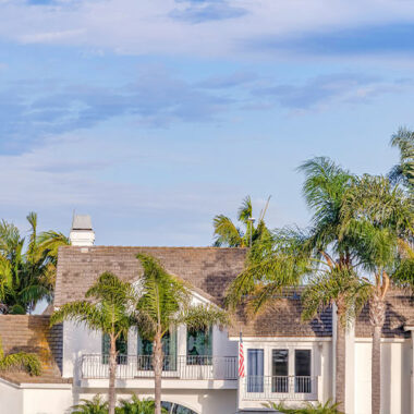 Painting high-end homes in Malibu & Pacific Palisades – luxury coastal home with palm trees and bright white exterior under a blue sky.