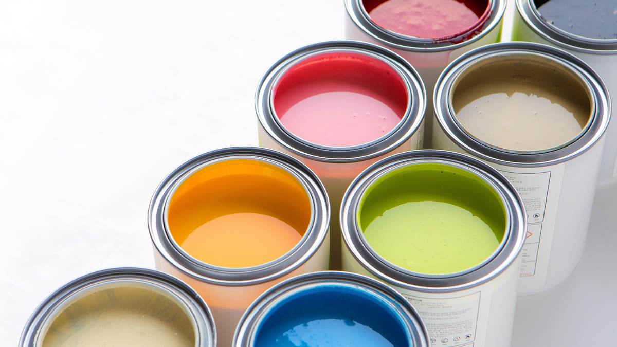 A close-up of multiple open paint cans in various vibrant colors, representing the quality materials essential for paint durability.