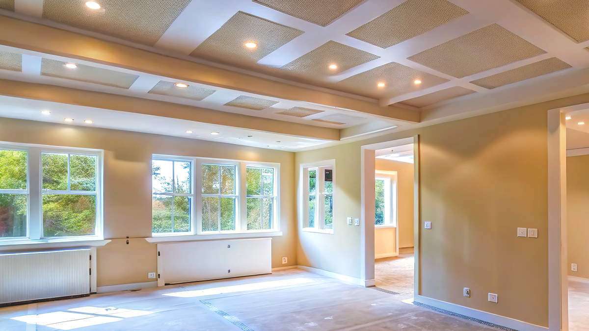 An interior room undergoing professional prep work for painting, with covered floors and walls ready for a fresh coat.