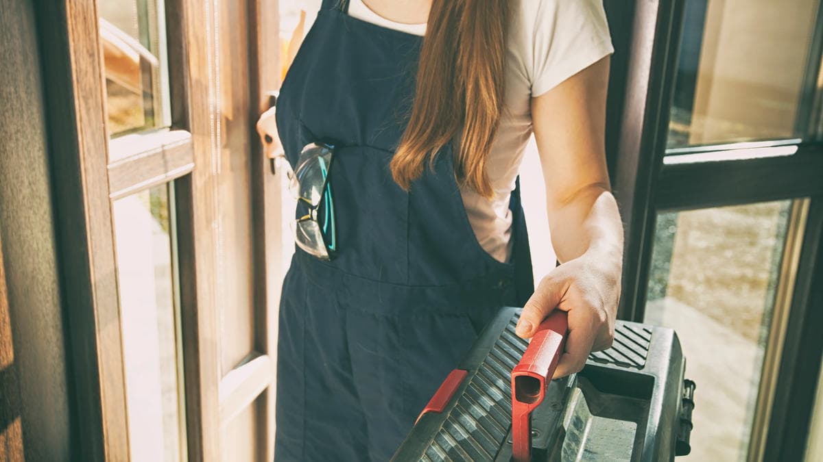 Los Angeles exterior prep contractor carrying tools at a front door, ready to inspect doors and windows for winter rain home protection.