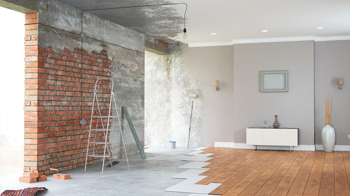Interior painting staged during a remodel with exposed brick, unfinished surfaces, and new flooring in a Los Angeles home