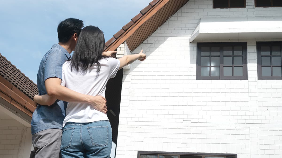 Homeowners reviewing exterior areas before scheduled house painting work